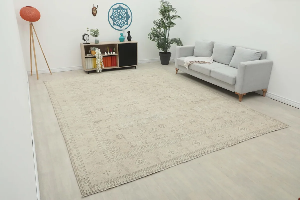 Oversized beige Persian rug displayed in a modern living room setting with a gray sofa