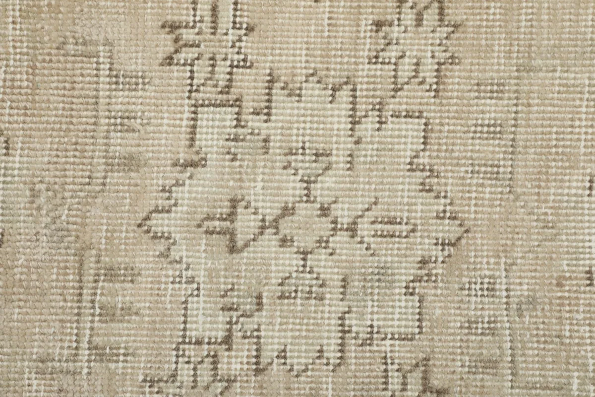 Detailed view of a distinct gray geometric pattern within the beige rug's field