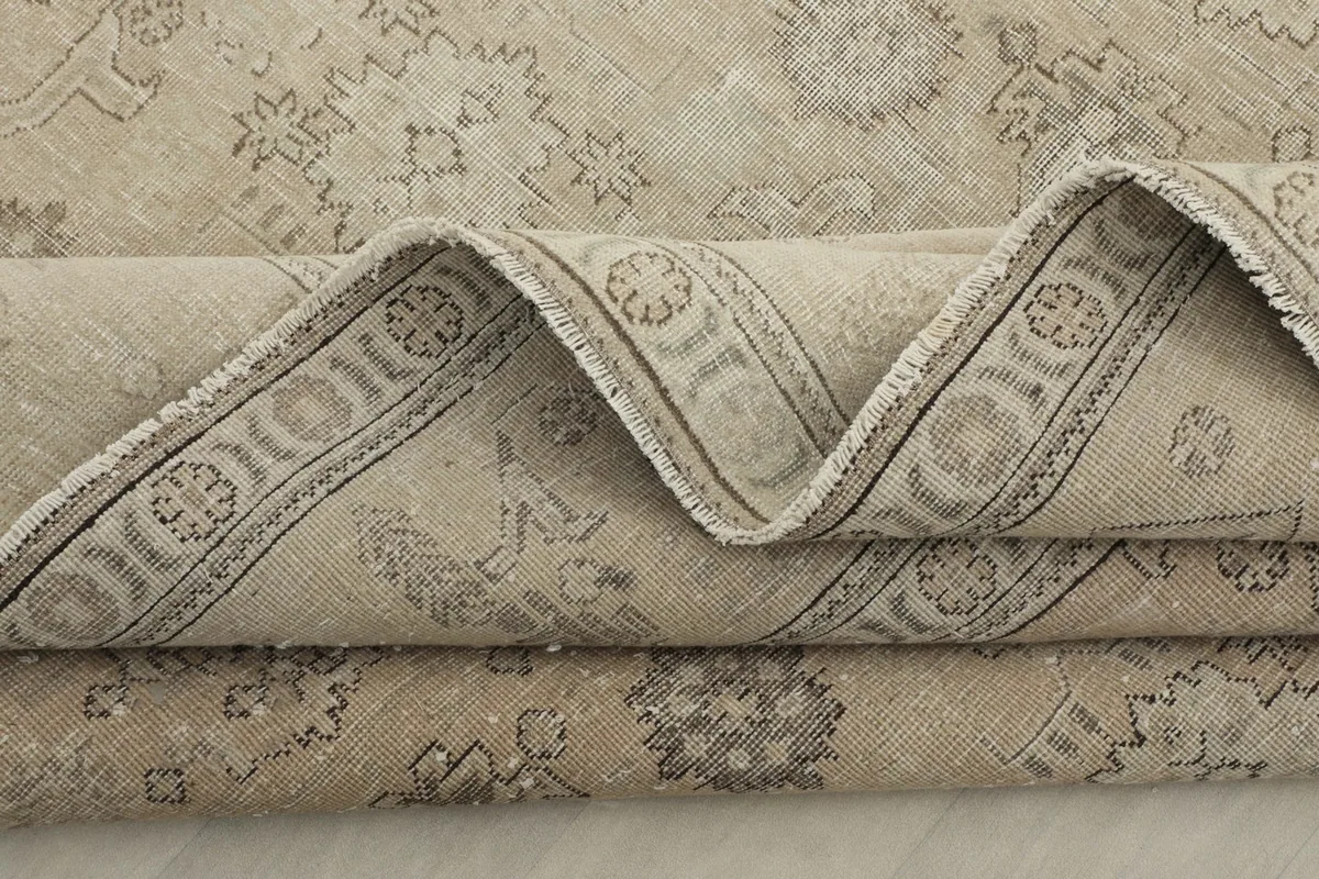Zig-zag fold of the rug showcasing the intricate gray border and main field pattern