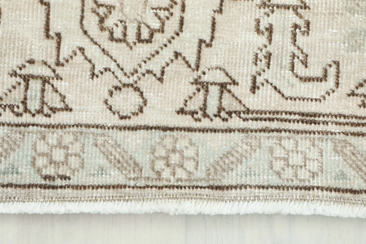 Close-up of the Cream Medallion Persian Rug's border and fringe, highlighting the low pile and intricate patterns.