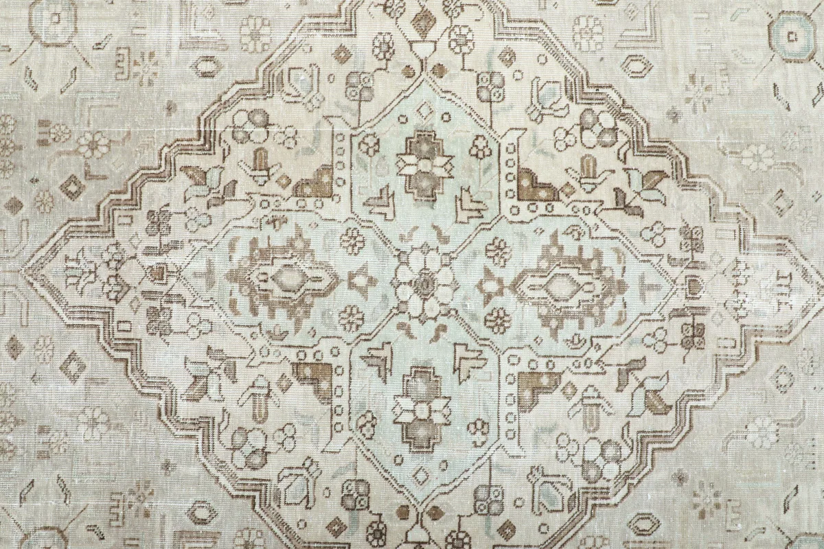 Detailed view of the Cream Medallion Persian Rug's central design, showing light green and brown accents.