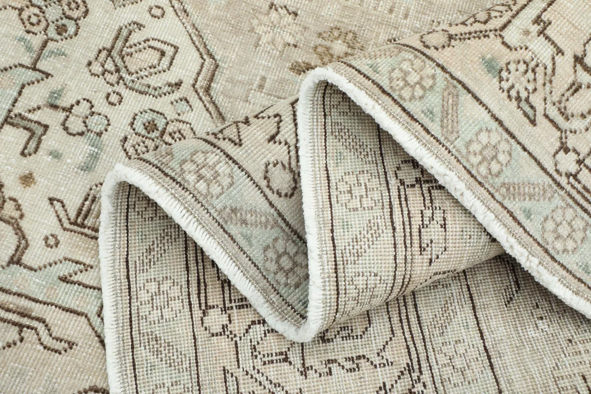 Folded section of the Cream Medallion Persian Rug, revealing the reverse side and cotton foundation.