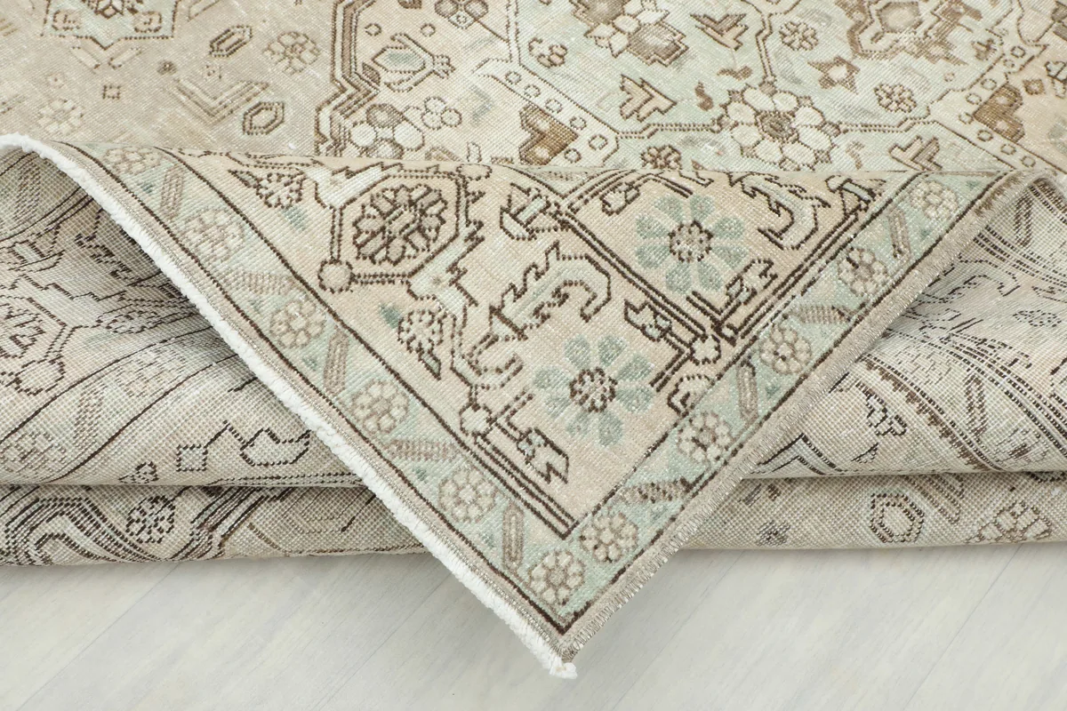 Another folded view of the Cream Medallion Persian Rug, highlighting the hand-knotted construction.