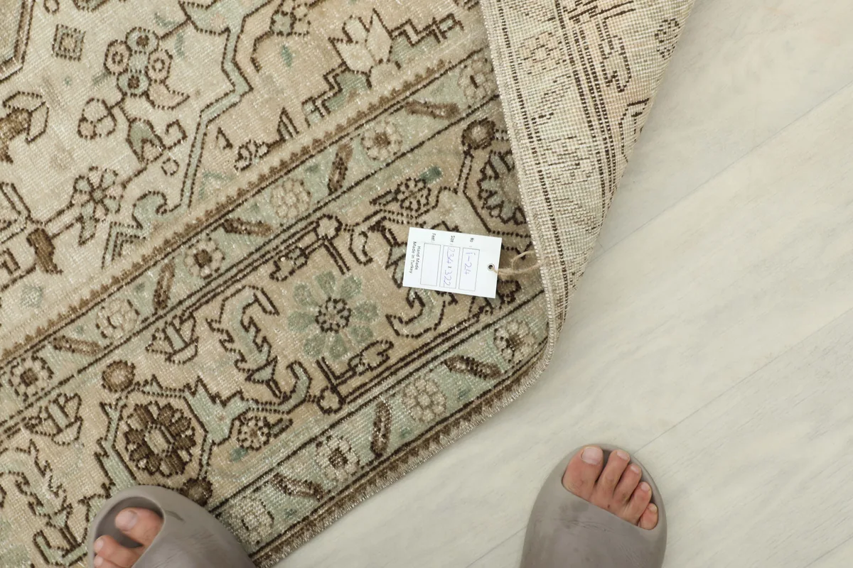 View of the Cream Medallion Persian Rug with a tag, showing the wool pile and general texture.