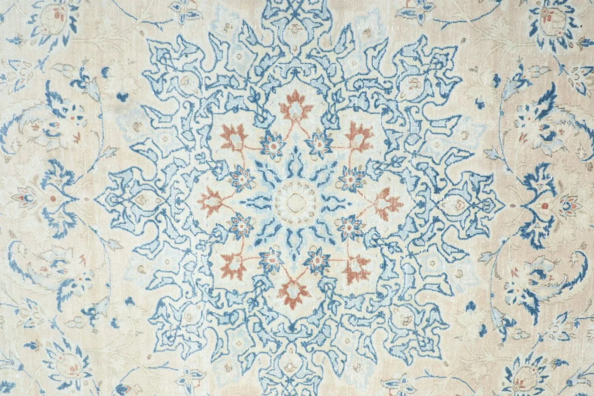 Detailed view of the central medallion with blue and rust floral elements.