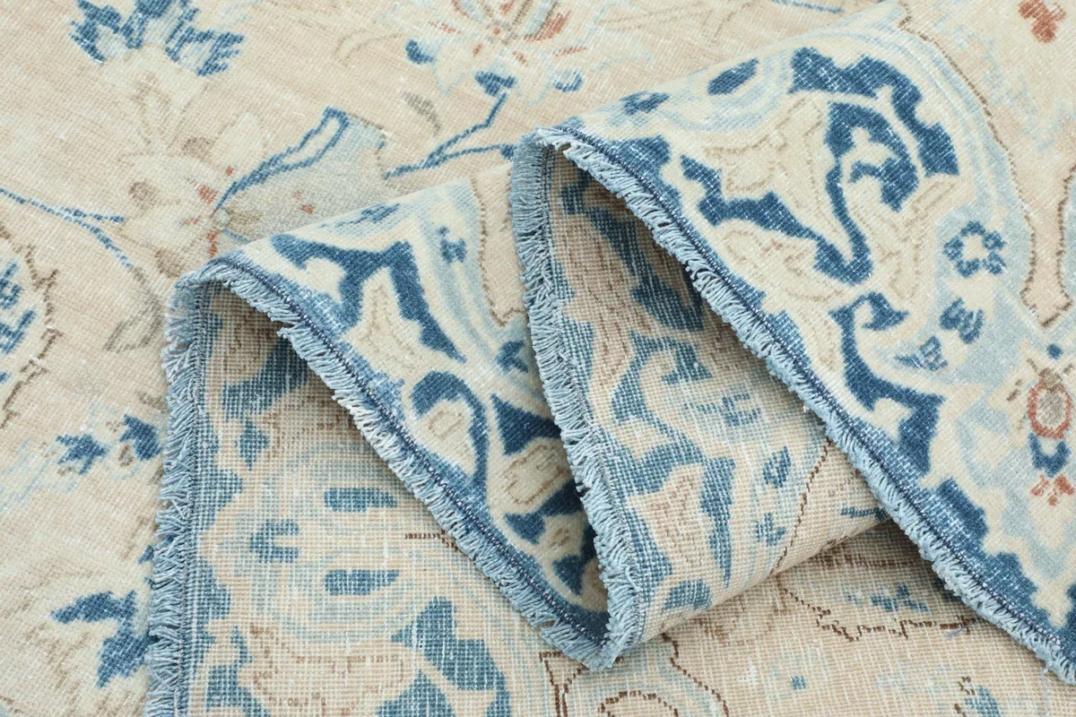 Folded section of the rug showing the thickness and detail of the blue border.