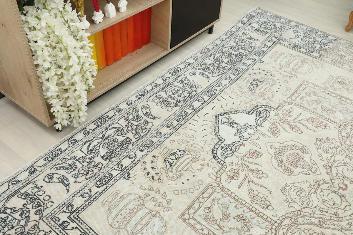 Another angled view of the rug's border and field, highlighting the faded gray patterns
