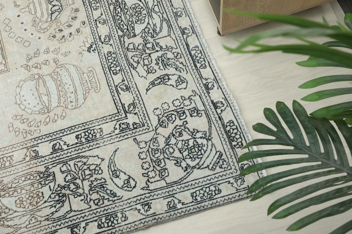 Detailed view of the charcoal gray border design with botanical and vase motifs