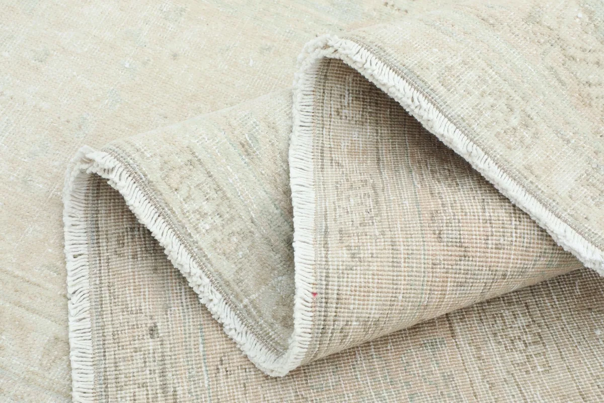 Folded section of the rug showing the low wool pile and cotton foundation texture