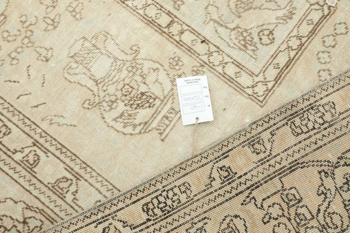 Corner of the rug with a tag, showing the intricate hand-knotted details and pattern