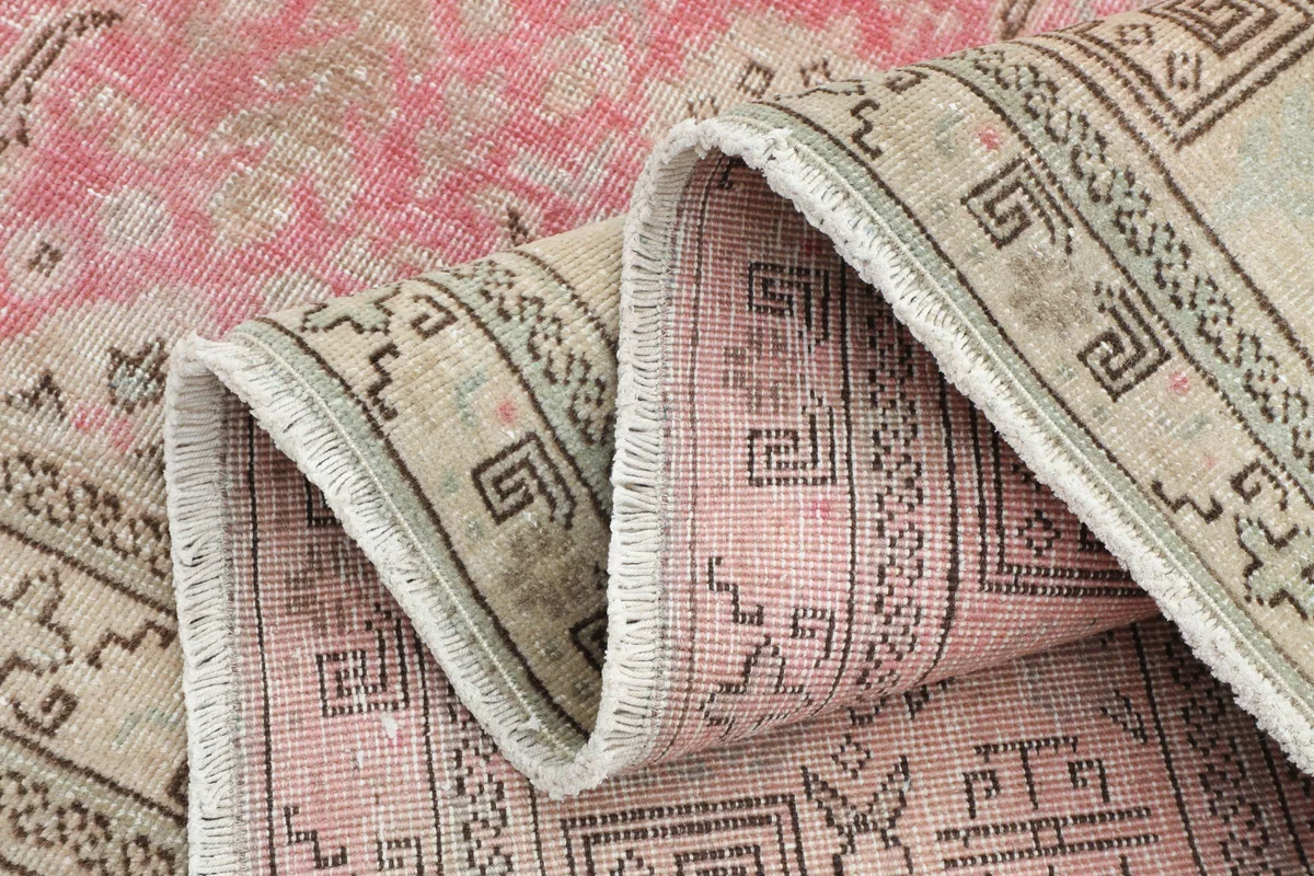 The Persian rug partially rolled, revealing the texture of the low pile and the construction of the border.