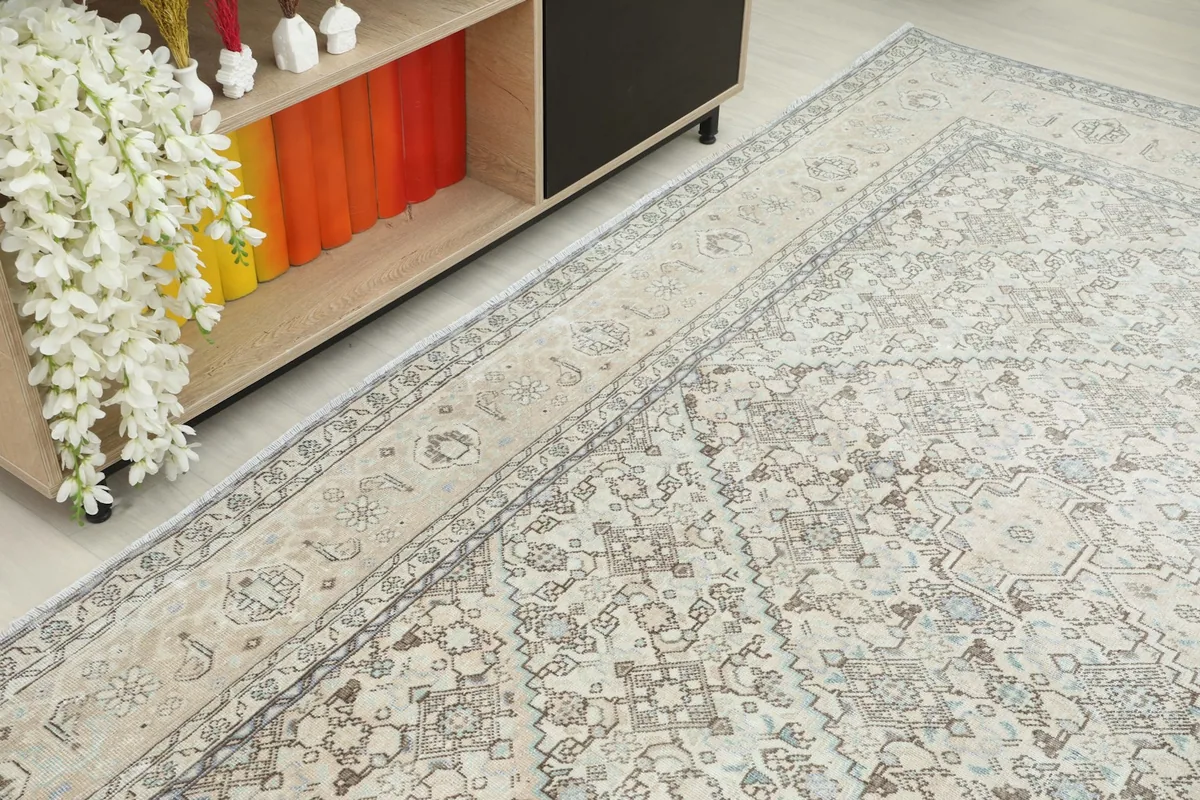 Angled shot of the rug in a room, showing its placement next to a light wood and black cabinet.