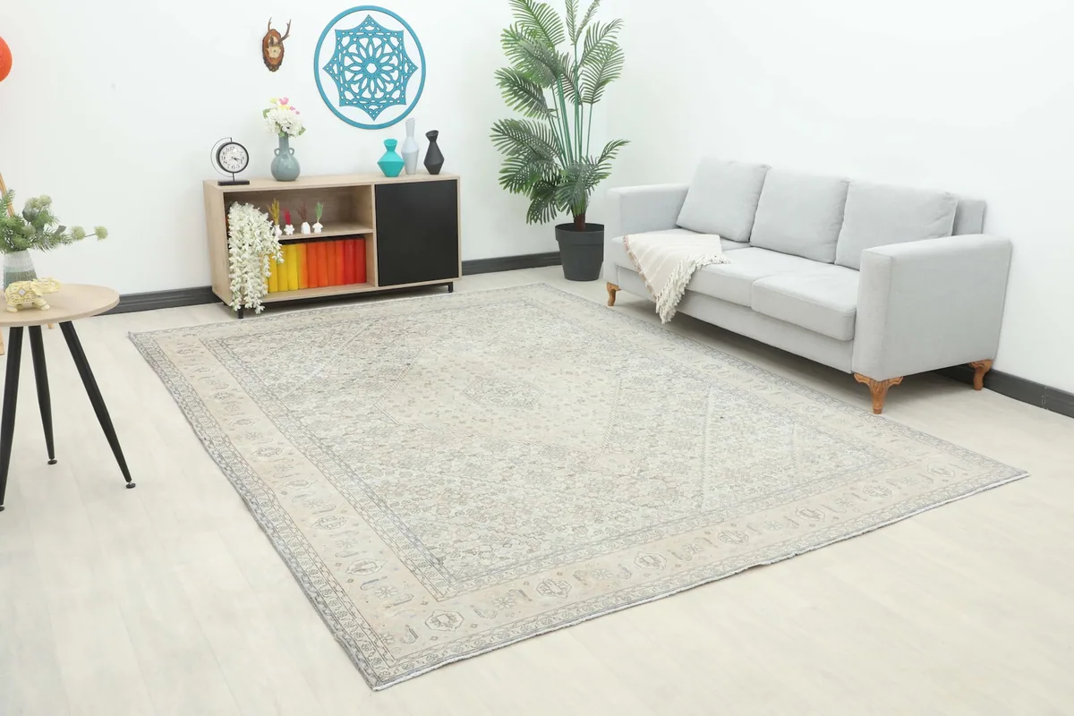 Vintage cream and gray Persian rug displayed in a bright living room setting with a light gray sofa.