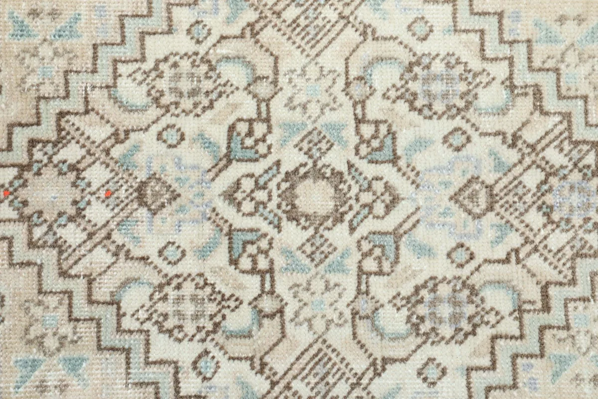 Macro detail of the rug's pile, showing the hand-knotted texture and subtle color variations in gray and blue.