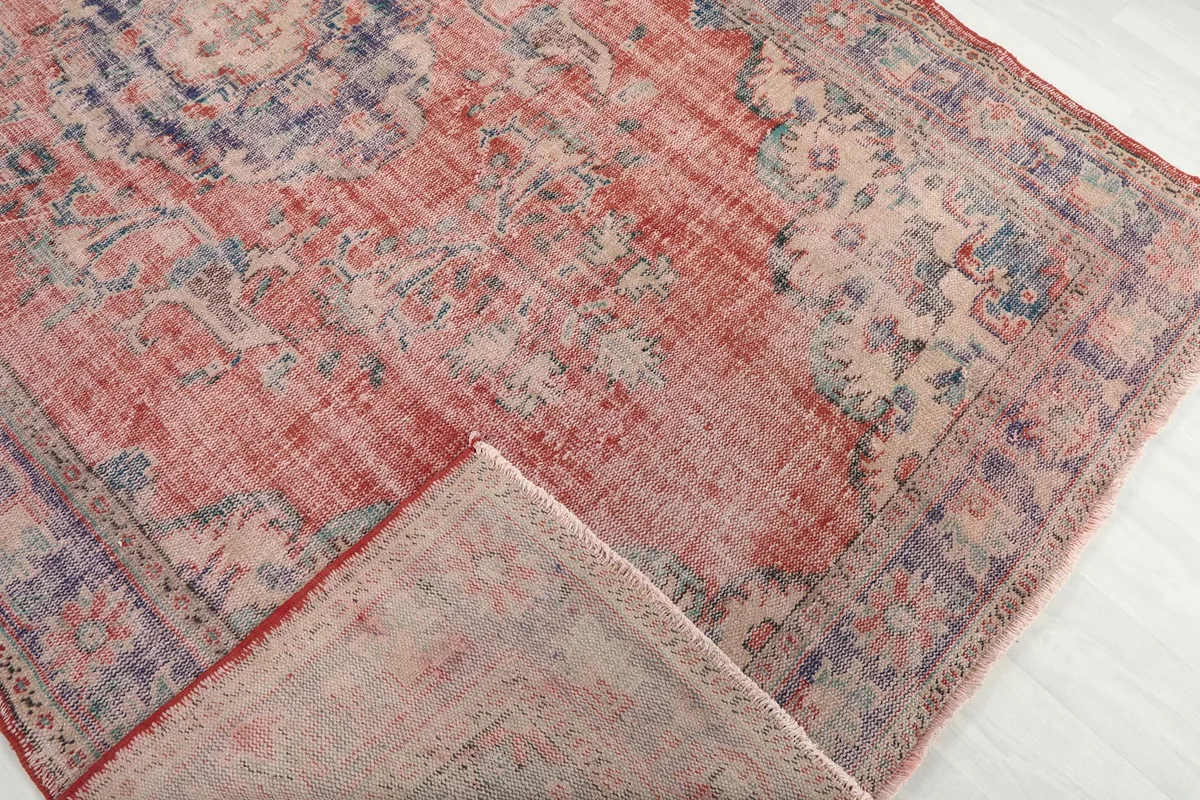 Corner of the rug folded back to show the reverse side and weave