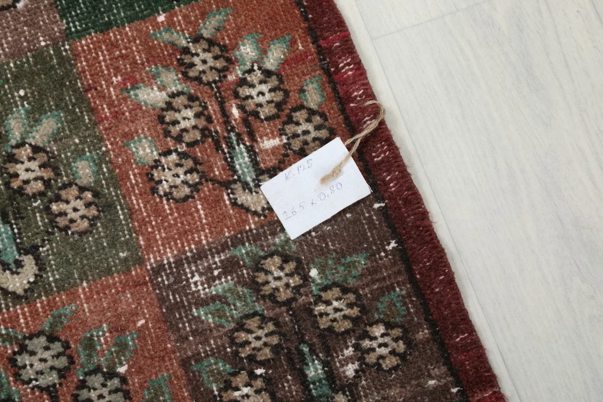 Close-up of a rug corner with a product tag, showing the texture and color detail