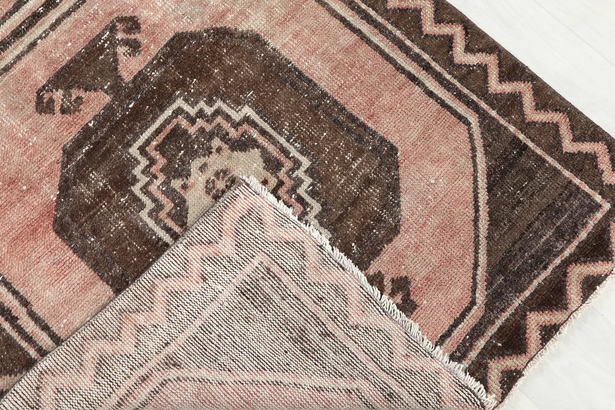 Corner of the rug folded to show the hand-knotted wool pile on cotton foundation from the back