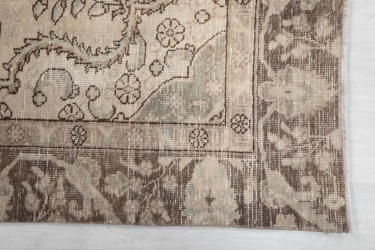 Detail of the rug's corner, showing the border design and faded green accents
