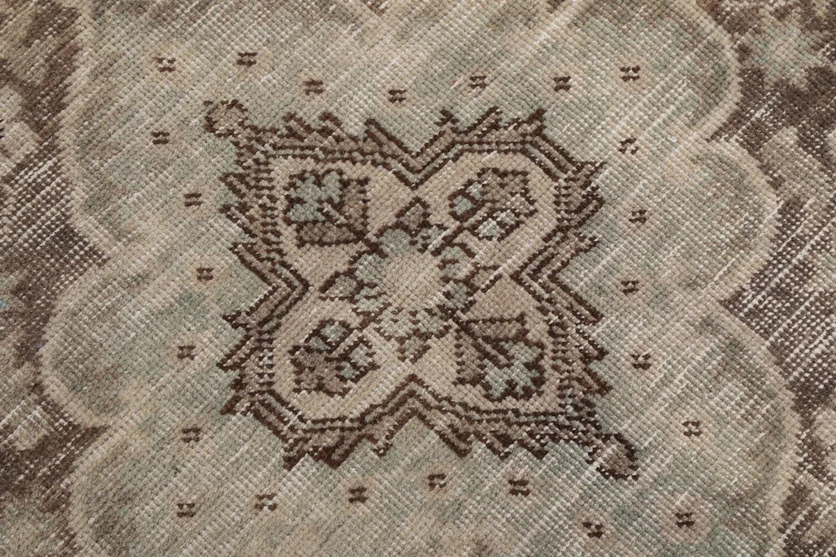 Extreme close-up of the central medallion's intricate pattern and muted green color