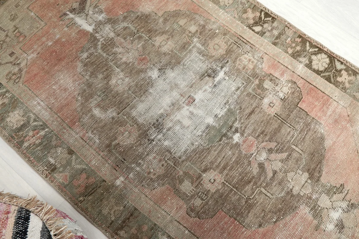Overhead angle showing the central medallion and areas of wear on the rose and brown field