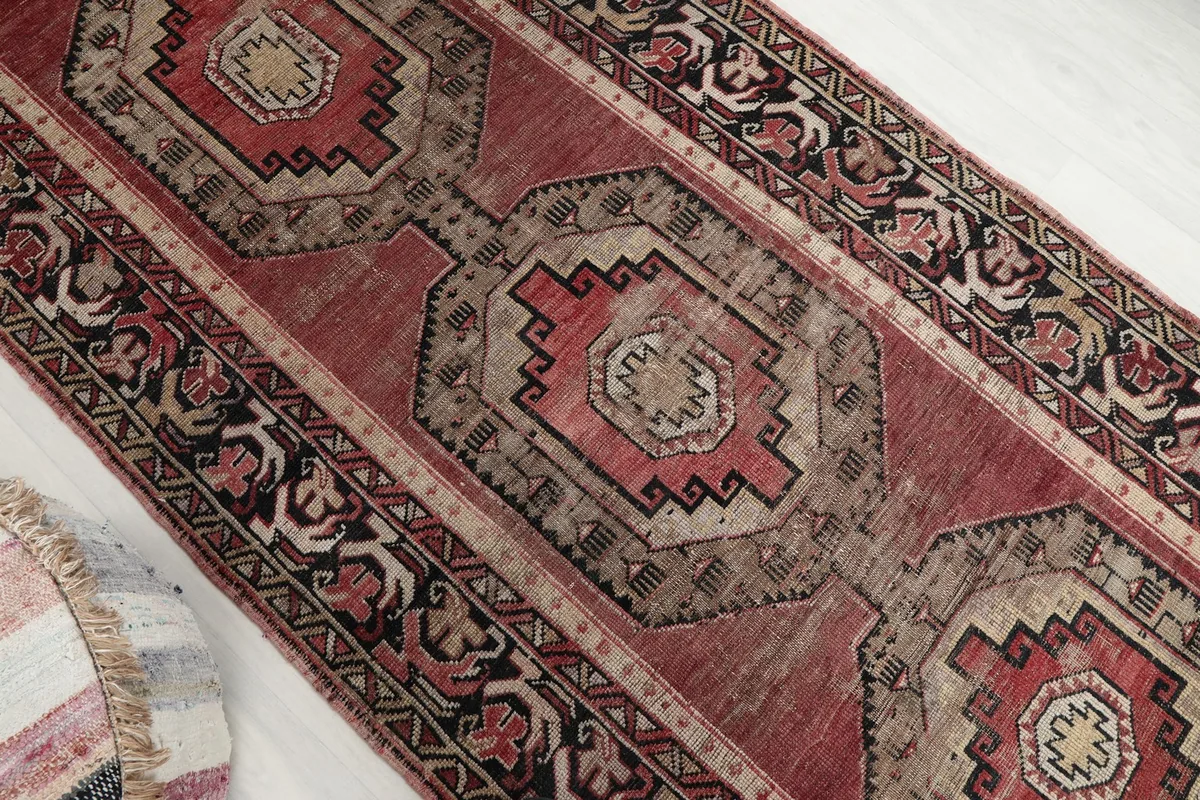Overhead angled shot highlighting the central geometric medallions and surrounding patterns of the rug.