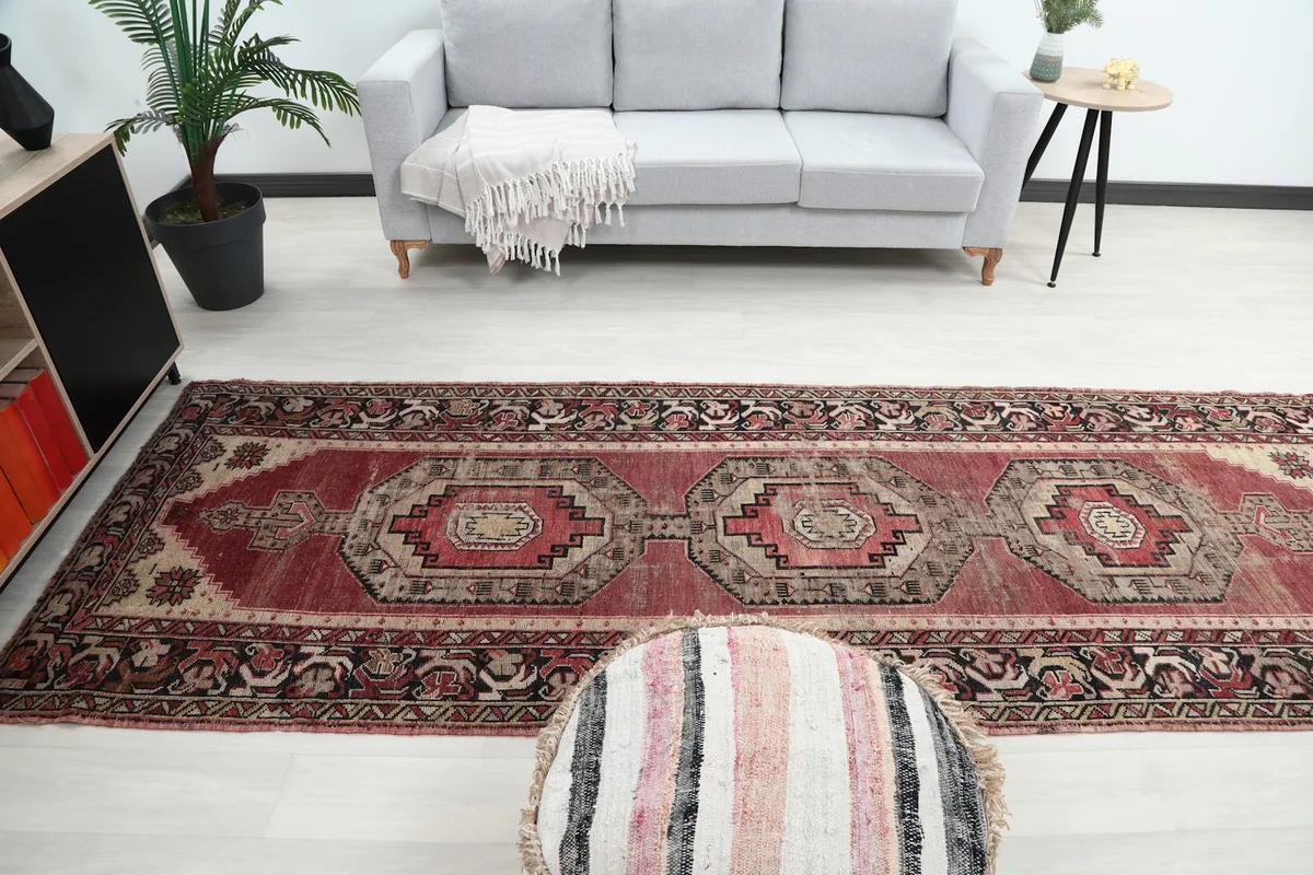 Overhead perspective of the runner rug in a room, with a gray couch and decorative elements in the background.