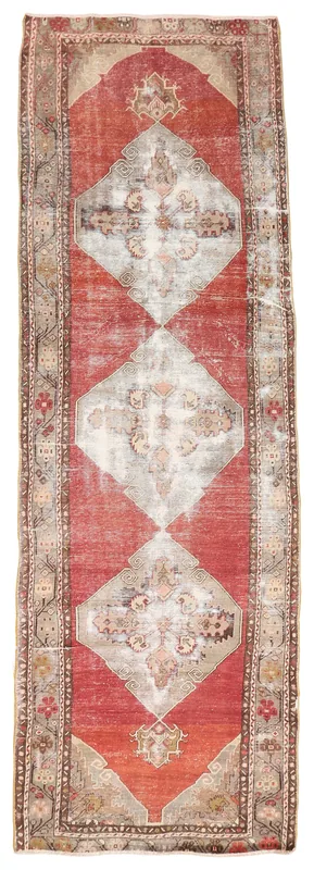 Full overhead view of the red and gray tribal medallion runner rug on a white background.