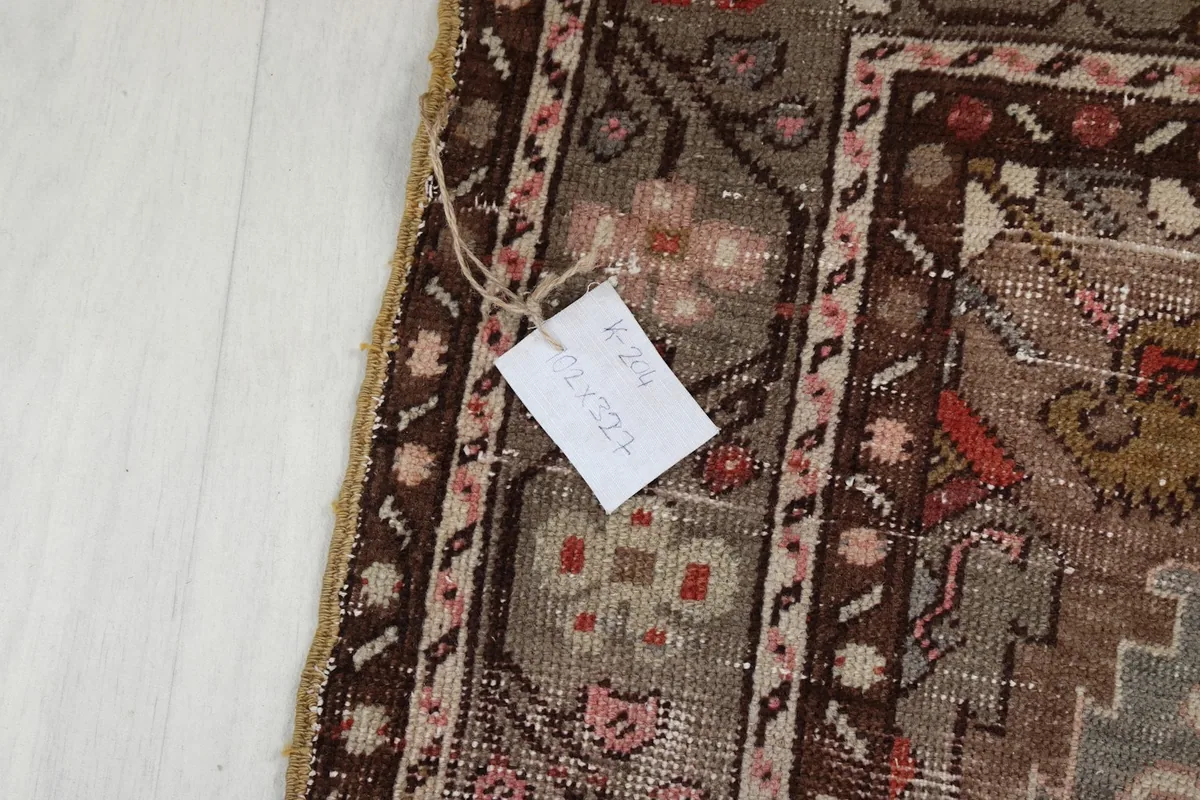 Close-up detail of the rug's border and fringe, with a tag showing product information.