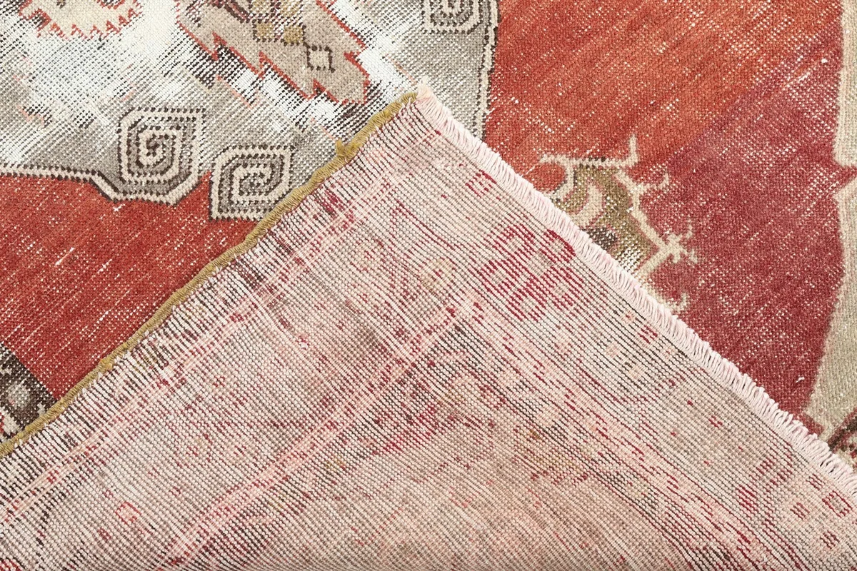 Corner view of the rug's back, revealing the hand-knotted cotton foundation and wool pile construction.