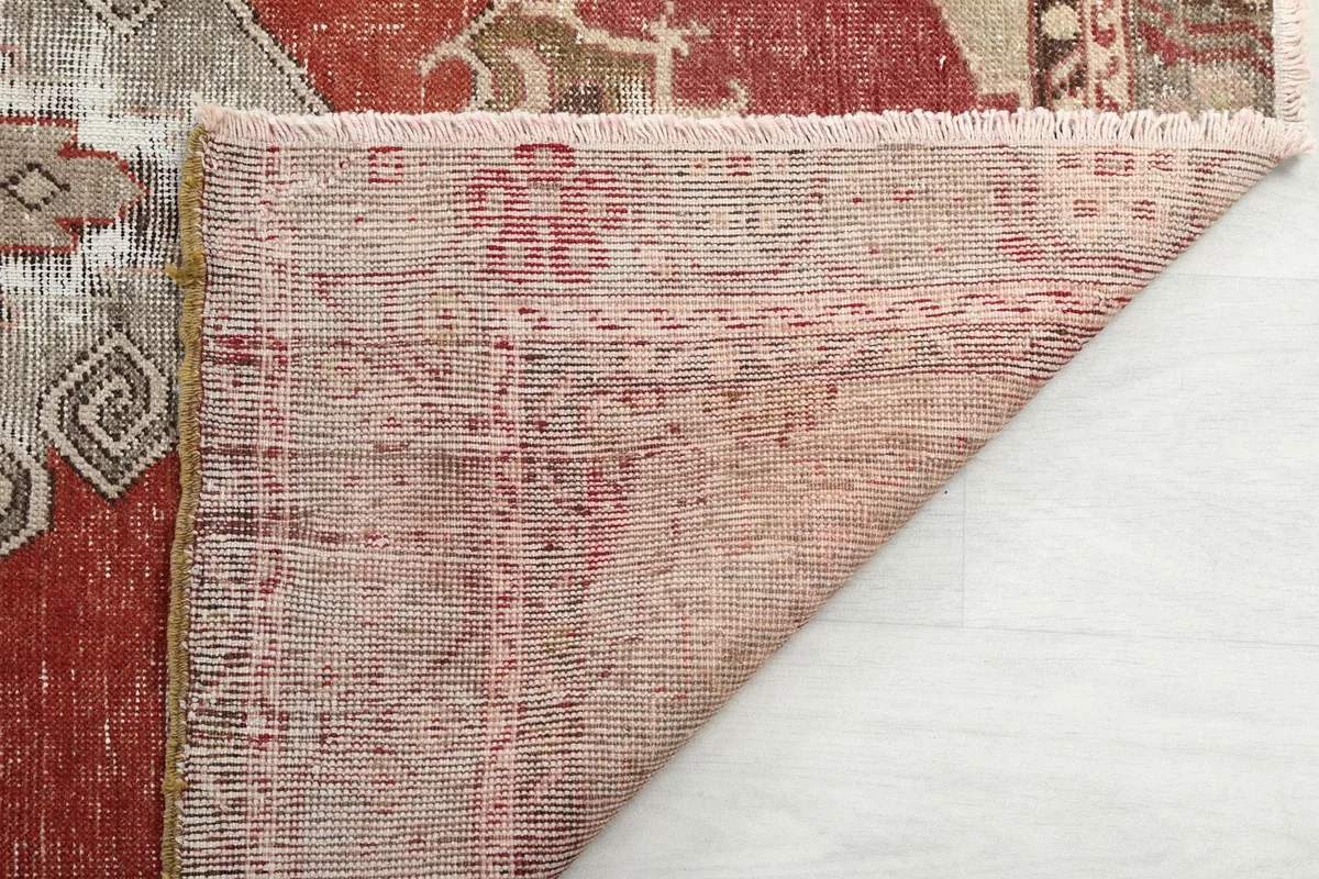Partial view of the rug's underside, showcasing the tight hand-knotted weave and fringe details.