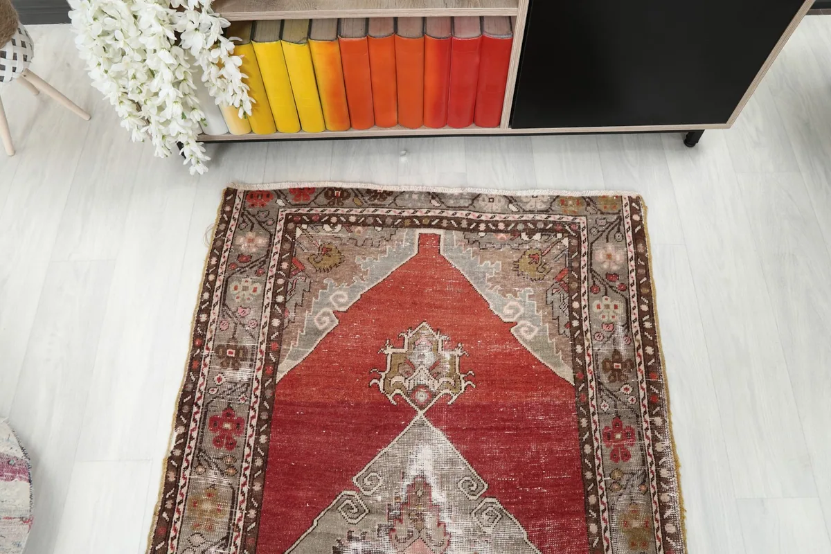 Overhead view of one end of the runner rug, showing the medallions and the distressed red field.
