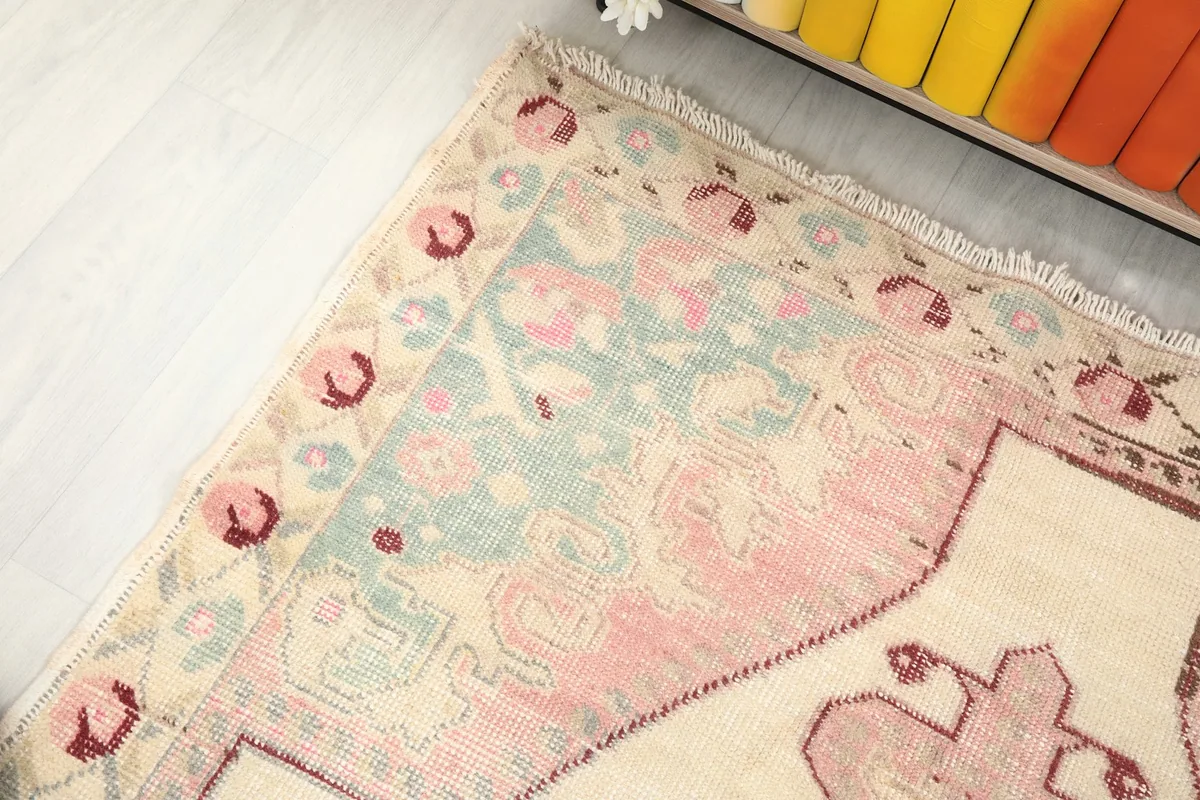 Detailed corner of the rug, showing the border design and muted green field