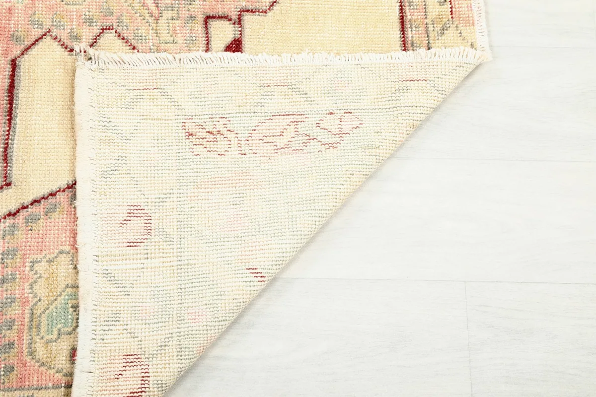 Reverse side of the rug, showing the knotting structure and a glimpse of the pile