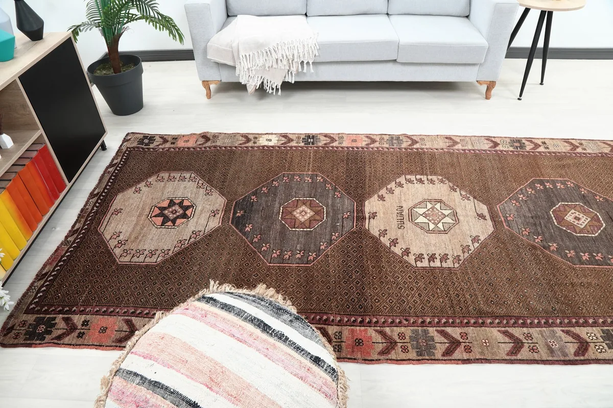 Long view of the brown area rug extending across a room with furniture