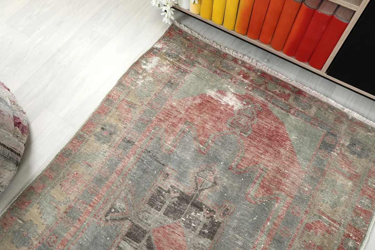 Angled view of the rug's end, showing its placement next to a bookshelf with colorful books.