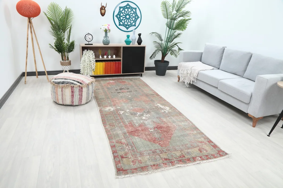 Angled view of the rust and gray runner rug in a room setting, showing its length and design.