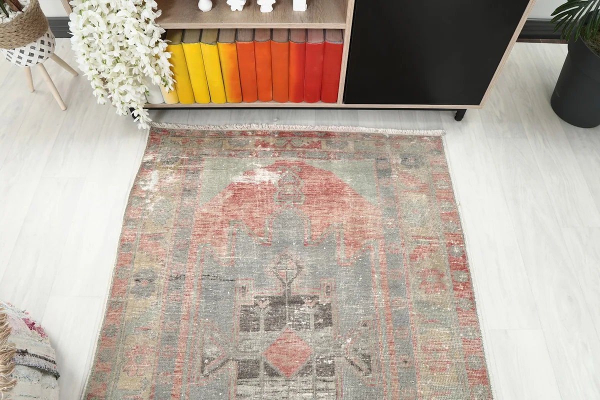 Overhead view of the rug's top half, revealing the intricate geometric design and faded appearance.