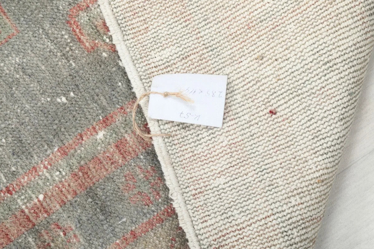 Close-up of the rug's back with a product tag attached, showing the tightly woven foundation.