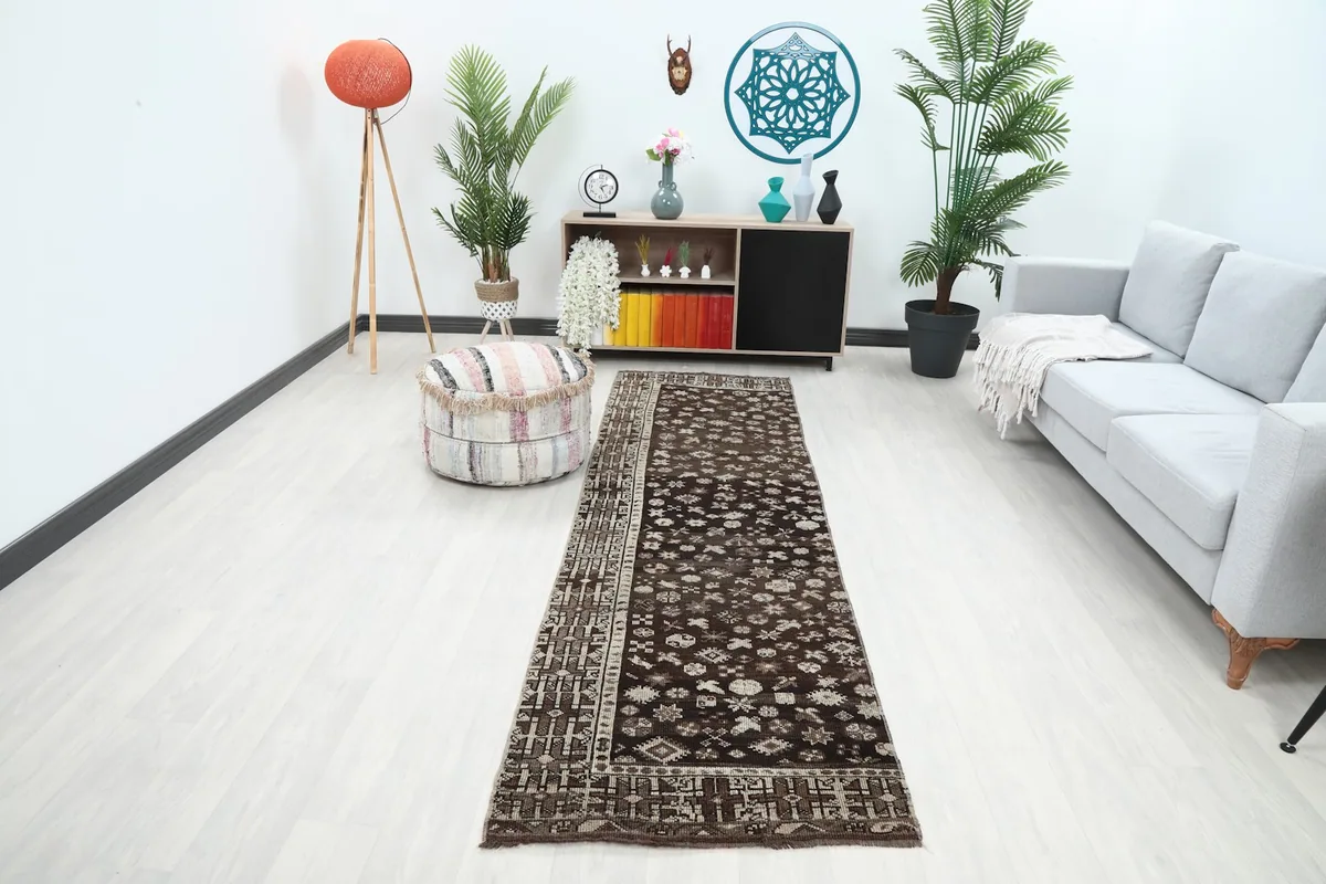 Vintage brown runner rug displayed in a modern hallway setting, showing its long shape and patterns.