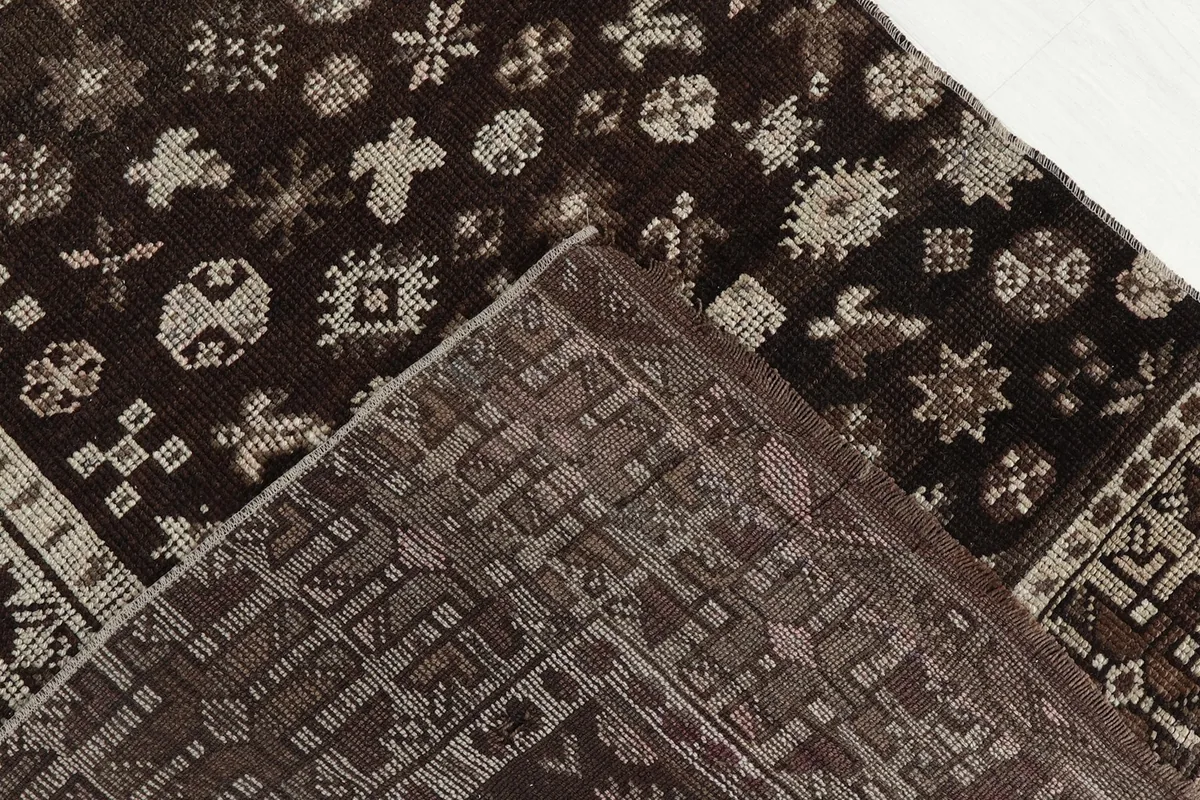Close-up showing the low wool pile of the rug and the detailed hand-knotted construction.