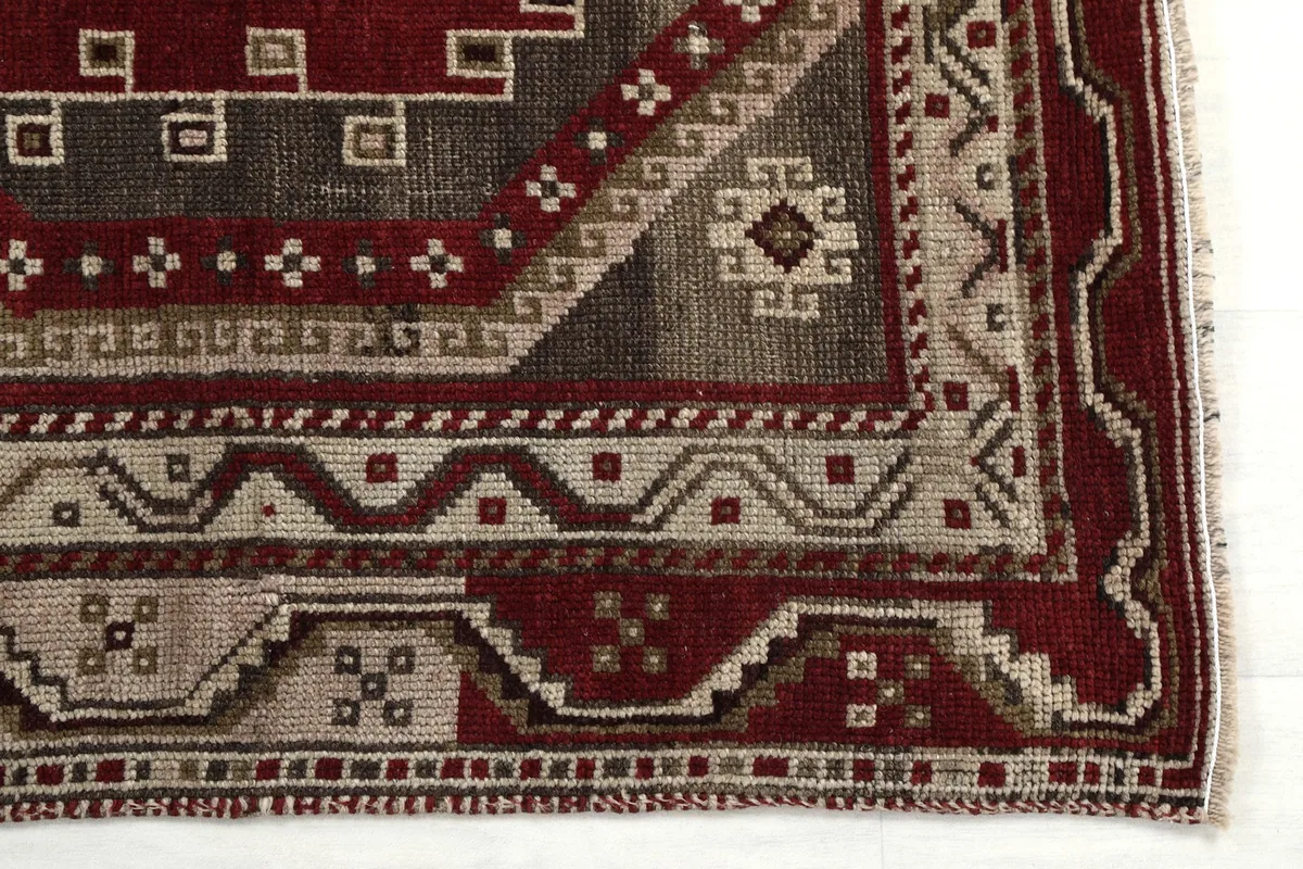 Detailed shot of the rug's corner, highlighting the intricate geometric border and main field pattern.