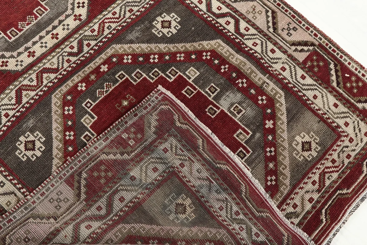 Corner of the rug folded back to reveal the hand-knotted construction on the reverse side.