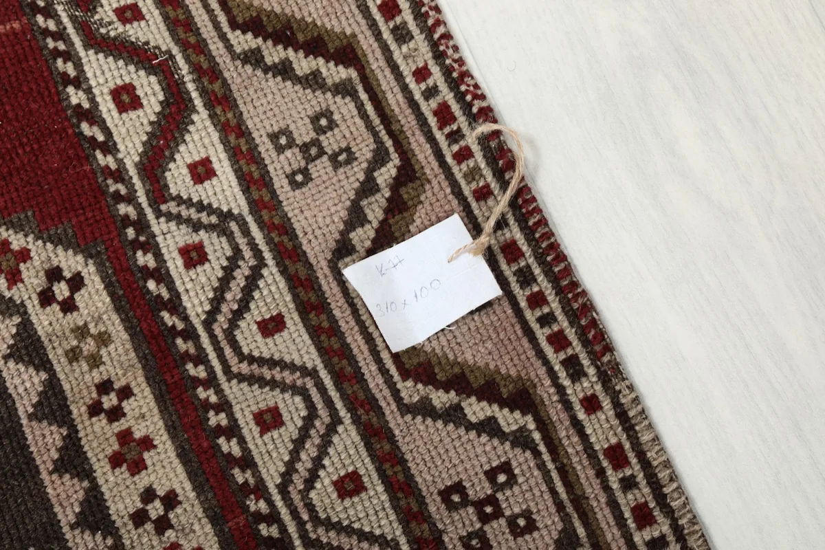 Detailed shot of the rug's edge and fringe, with a product tag visible.