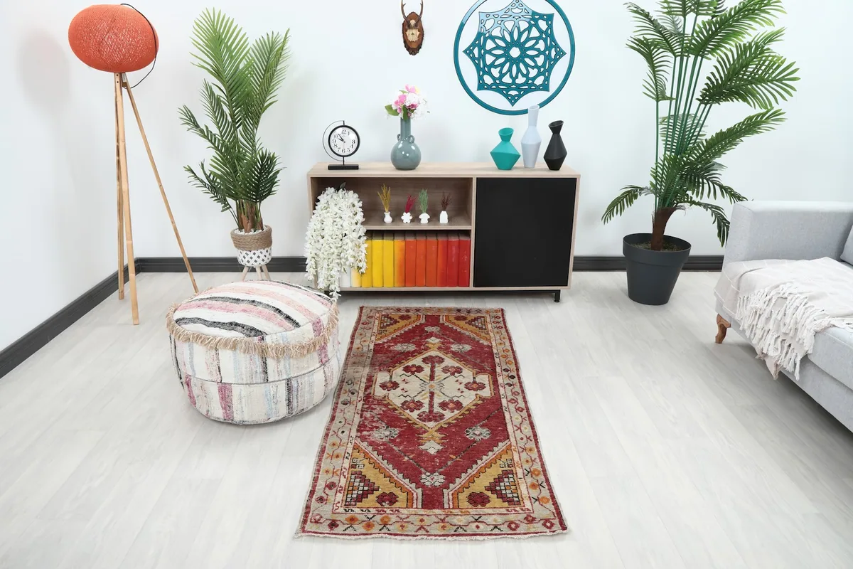 Vintage red and yellow rug placed in a living room setting with modern furniture