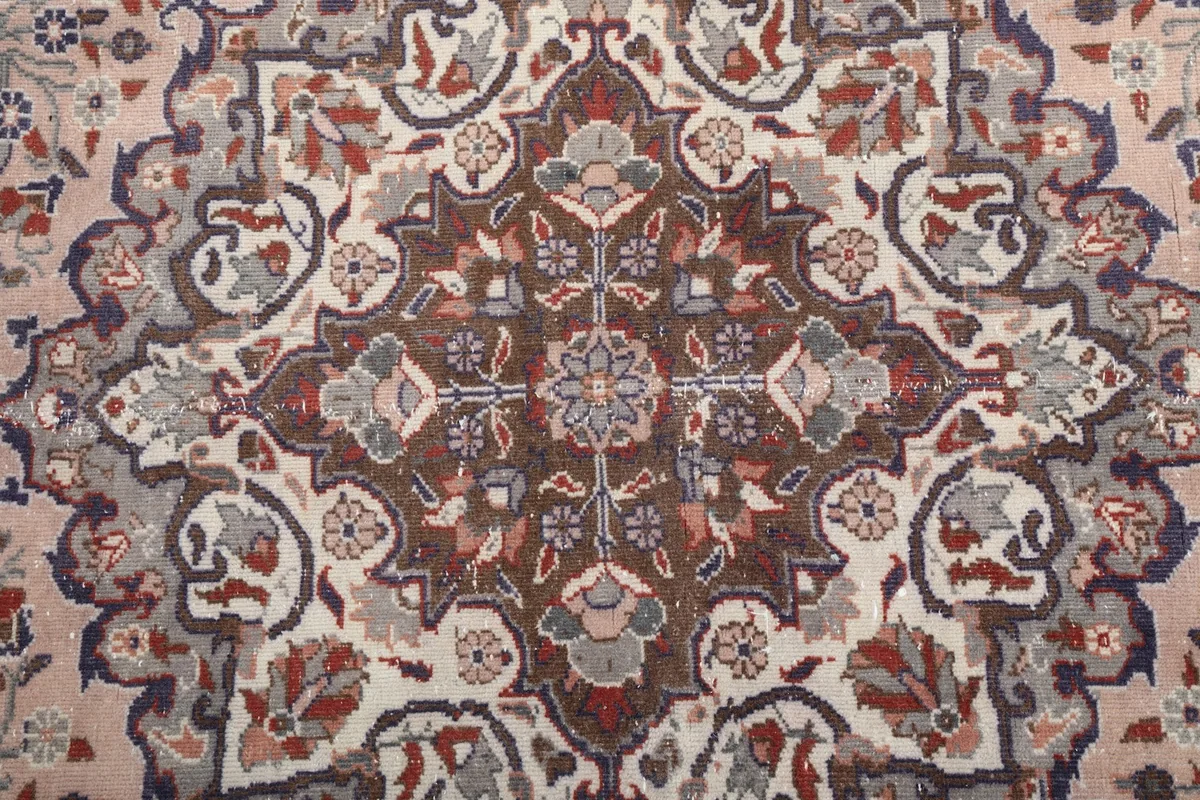 Close-up of the central medallion with brown, cream, and gray floral motifs