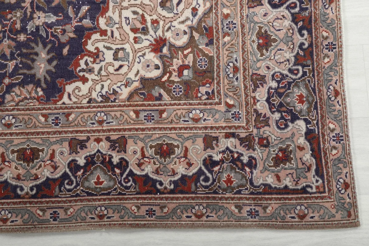 Detailed view of the intricate floral and geometric patterns in the rug's border