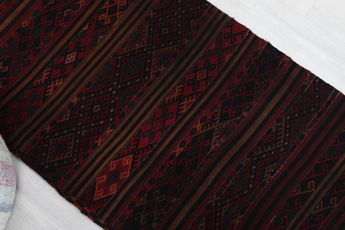 Angled view highlighting the striped and diamond tribal motifs of the rug