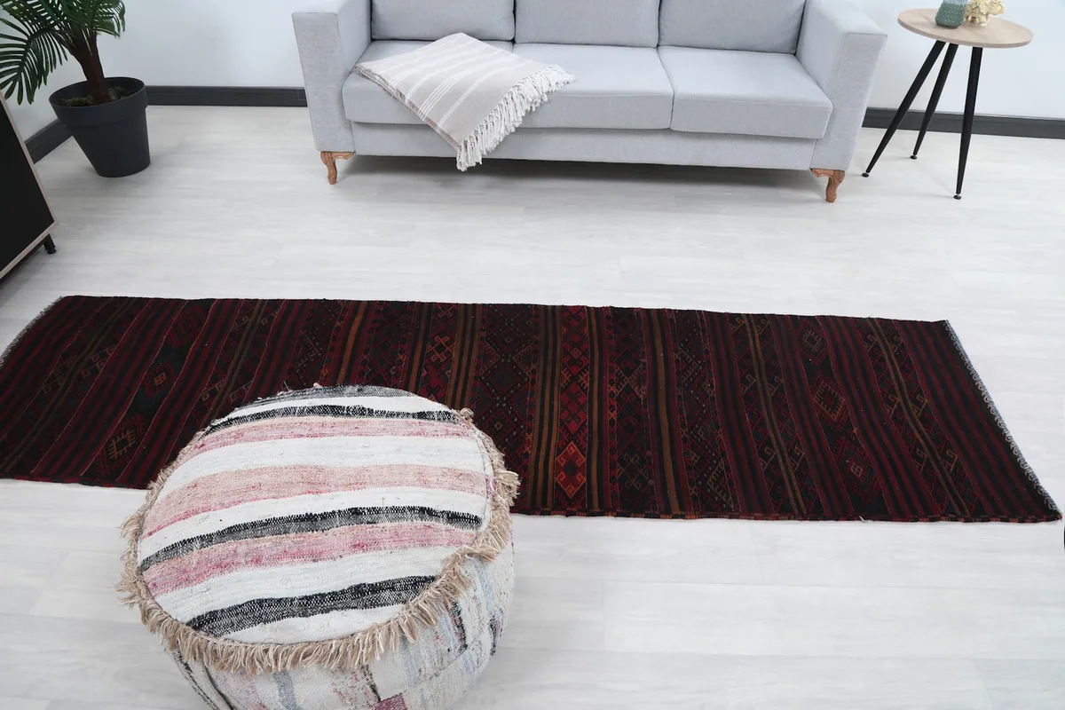 Long shot of the red runner rug in a room, showing its full length and scale