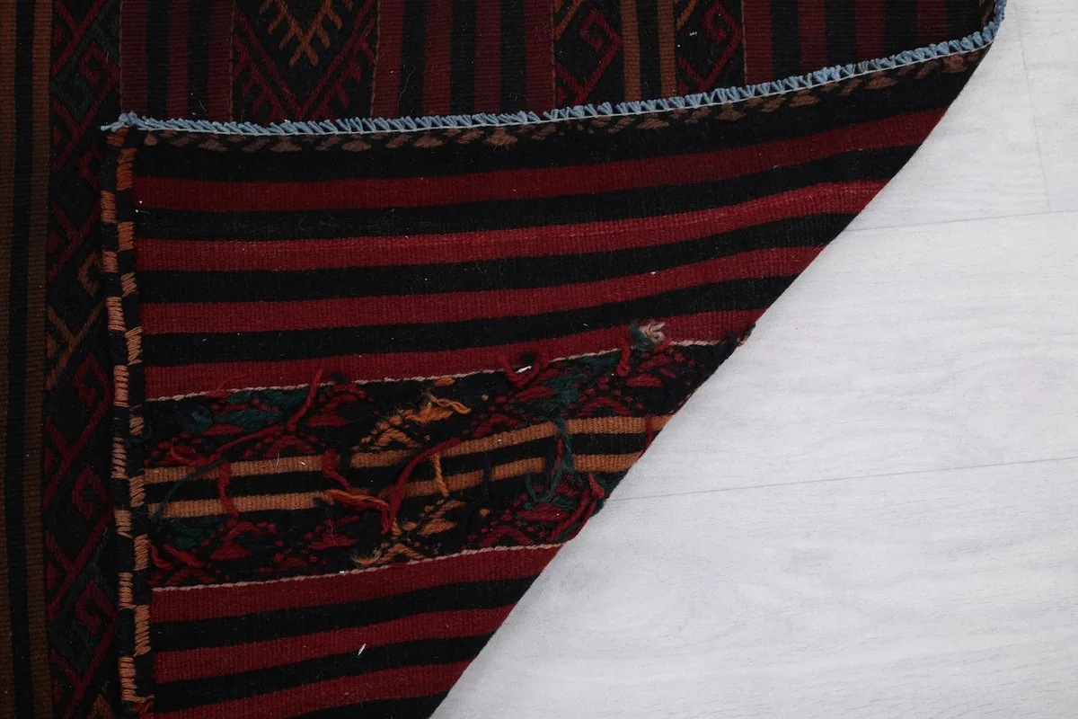 Folded corner of the rug displaying the reverse side and construction