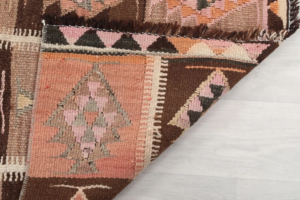 Folded corner of the rug, showing the reverse side and the fringe detail.